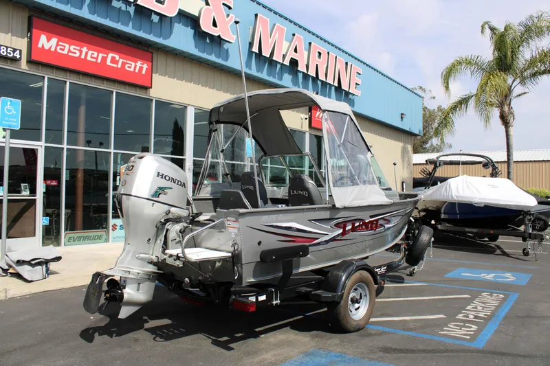 Slide: The Image of 2013 Lund 1675 Impact Sport boat with Honda engine at a marine dealership. - 21