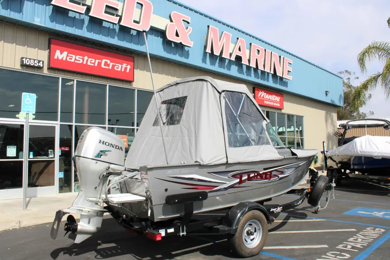 Slide: The Image of 2013 Lund 1675 Impact Sport boat with Honda motor outside marine store. - 24