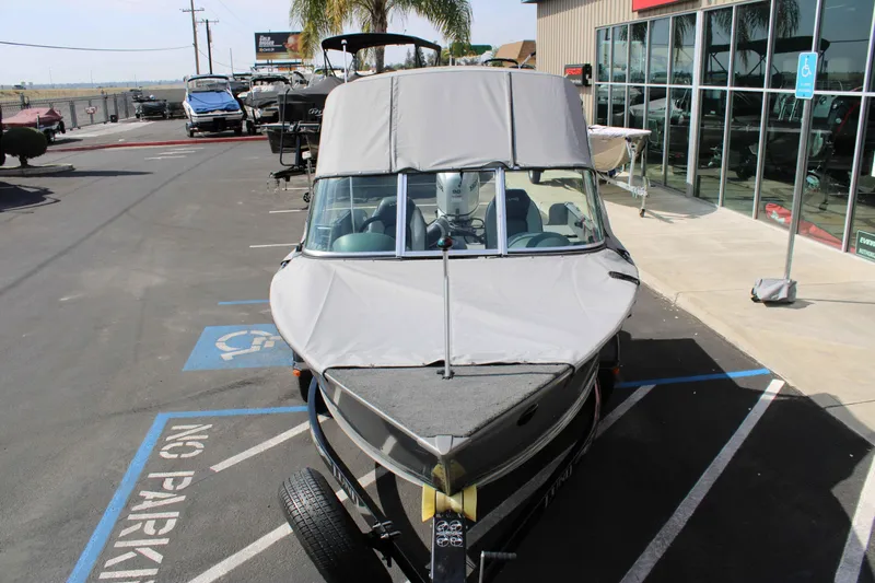 Slide: The Image of 2013 Lund 1675 Impact Sport boat with cover, parked in a dealership lot. - 4