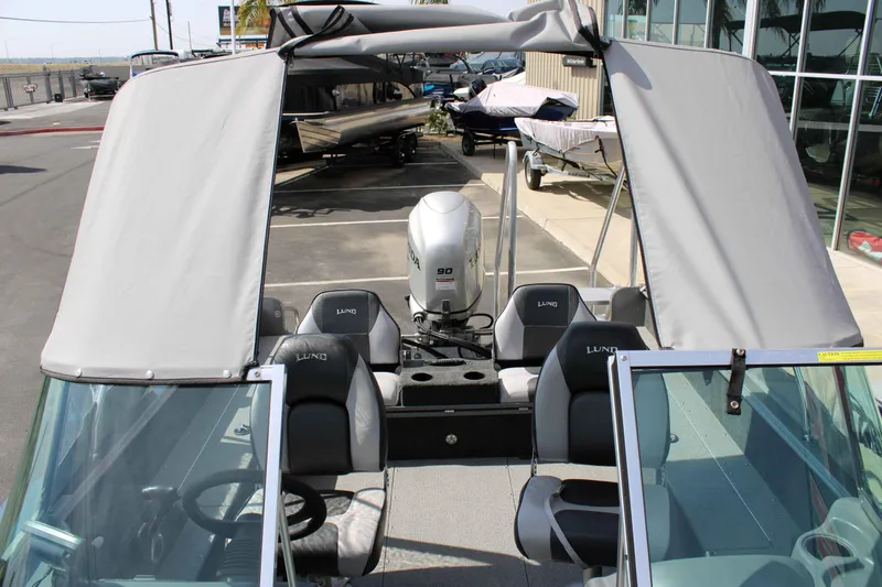 Slide: The Image of 2013 Lund 1675 Impact Sport boat with canopy and seating, parked outdoors. - 5