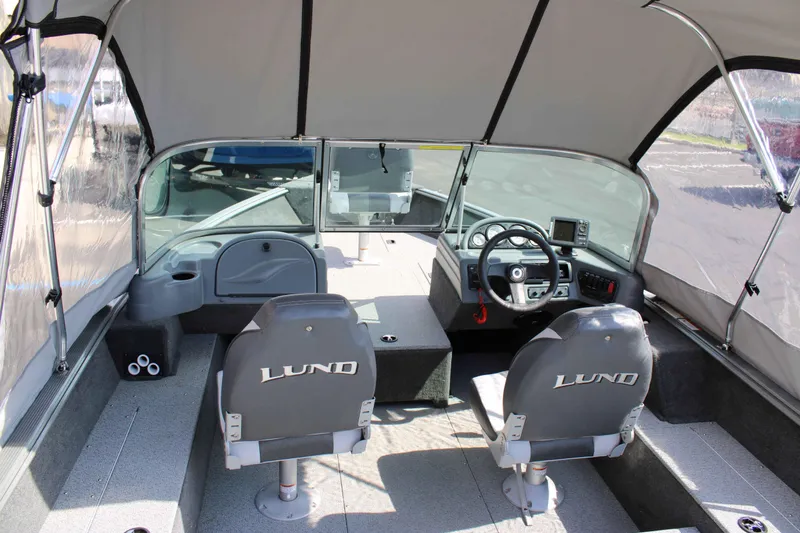 Slide: The Image of Interior of a 2013 Lund 1675 Impact Sport boat with steering console and seating. - 7