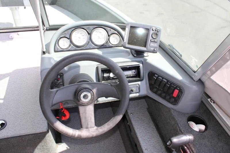 Slide: The Image of 2013 Lund 1675 Impact Sport boat dashboard with steering wheel and navigation system. - 9