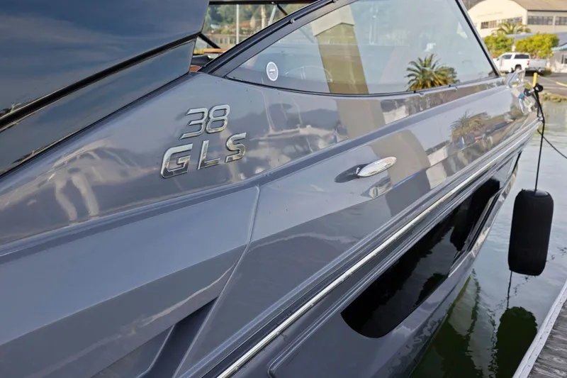 Slide: The Image of 2022 Cruisers Yachts 38 GLS South Beach IO, sleek design, docked by palm trees. - 11