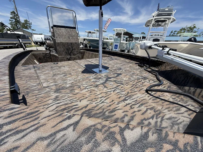 Slide: The Image of 2025 Xpress Hyper-Lift H190 Bay Series boat with camo deck, parked outdoors. - 6