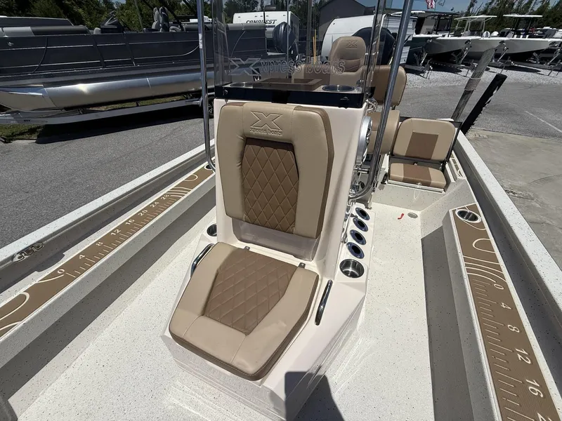 Slide: The Image of 2025 Xpress Hyper-Lift Bay Series H24 BAY boat interior with tan seating and measuring ruler. - 11