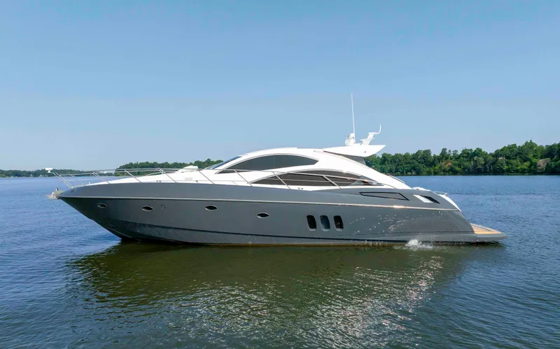 The Image of 2009 Sunseeker Predator 62 yacht cruising on a calm lake under a clear blue sky. - 0