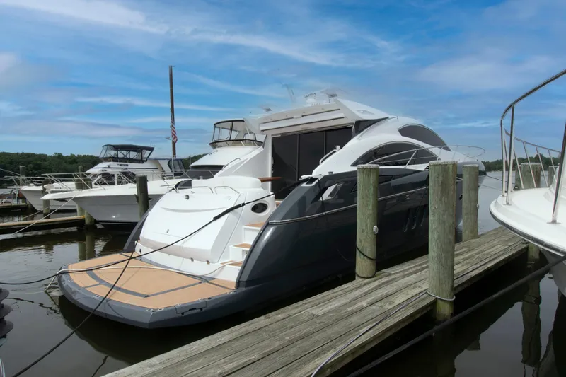 Slide: The Image of 2009 Sunseeker Predator 62 yacht docked at marina under blue sky. - 12