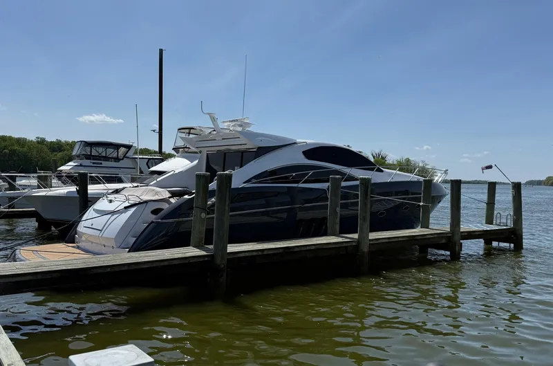 Slide: The Image of 2009 Sunseeker Predator 62 yacht docked at a marina under clear blue skies. - 13