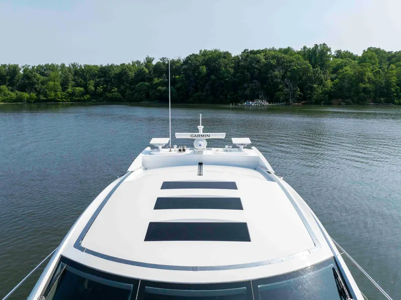 Slide: The Image of 2009 Sunseeker Predator 62 yacht on a serene lake with lush green trees. - 14