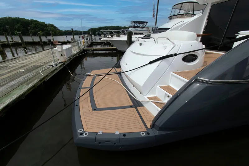 Slide: The Image of 2009 Sunseeker Predator 62 yacht docked, showcasing sleek design and spacious deck area. - 15