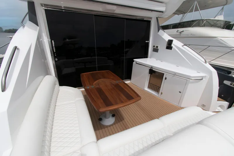Slide: The Image of Luxurious 2009 Sunseeker Predator 62 yacht deck with elegant seating and wooden table. - 18