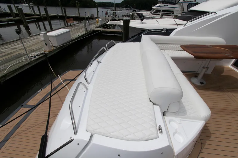 Slide: The Image of 2009 Sunseeker Predator 62 yacht with white cushioned seating at the dock. - 21
