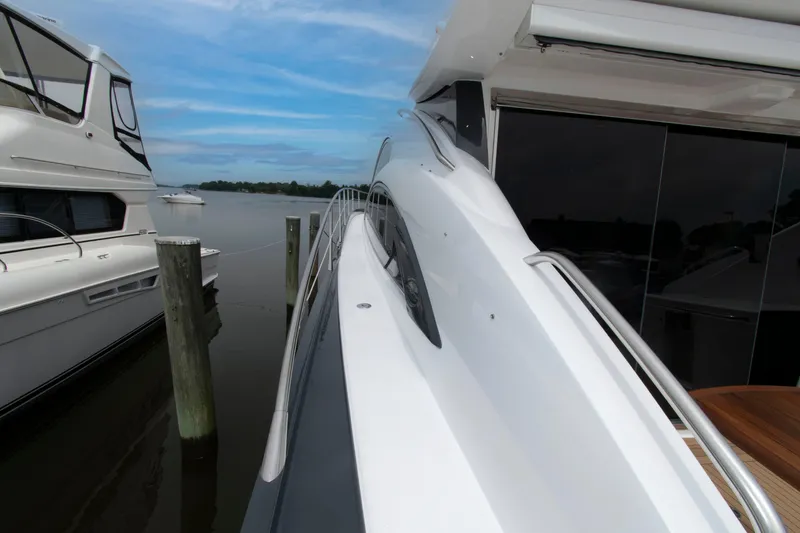 Slide: The Image of 2009 Sunseeker Predator 62 yacht docked, showcasing sleek design and modern features. - 25
