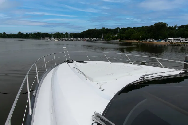 Slide: The Image of 2009 Sunseeker Predator 62 yacht on calm water, surrounded by lush greenery. - 30