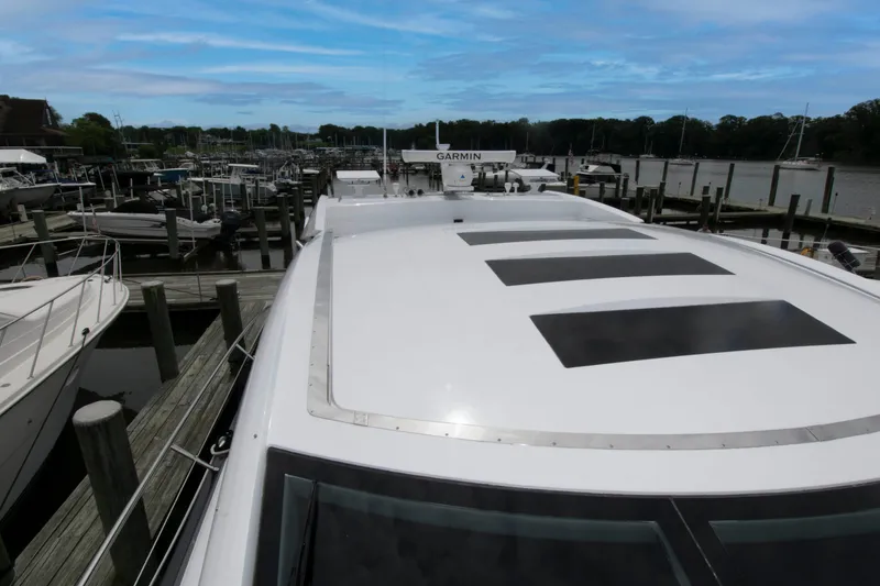 Slide: The Image of 2009 Sunseeker Predator 62 yacht docked at marina, showcasing sleek design and spacious deck. - 31