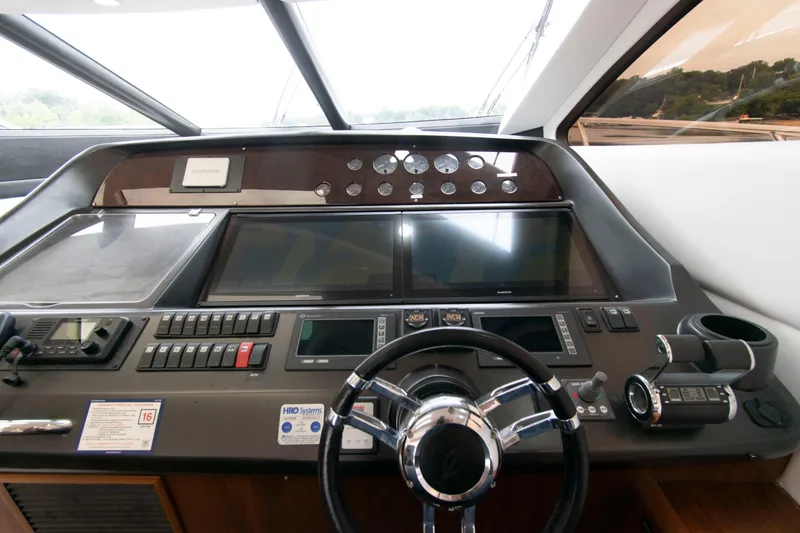 Slide: The Image of Control panel of 2009 Sunseeker Predator 62 yacht with steering wheel and navigation instruments. - 42