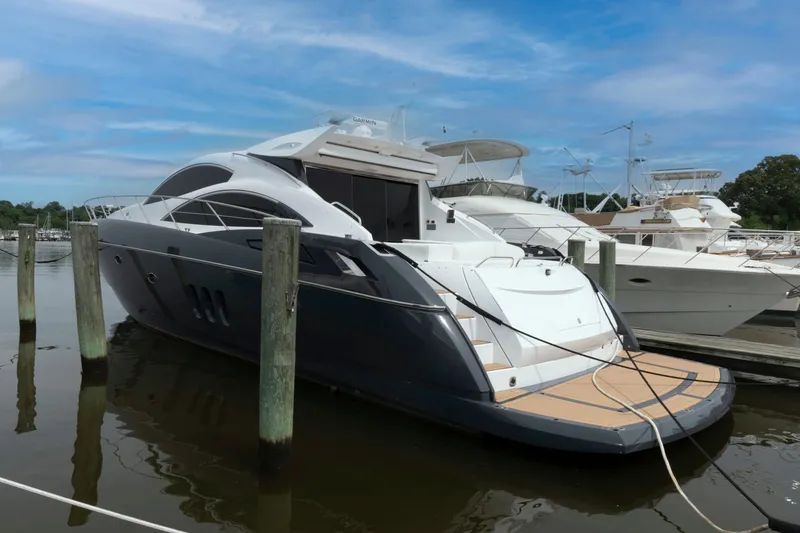 Slide: The Image of 2009 Sunseeker Predator 62 yacht docked at marina under blue sky. - 7