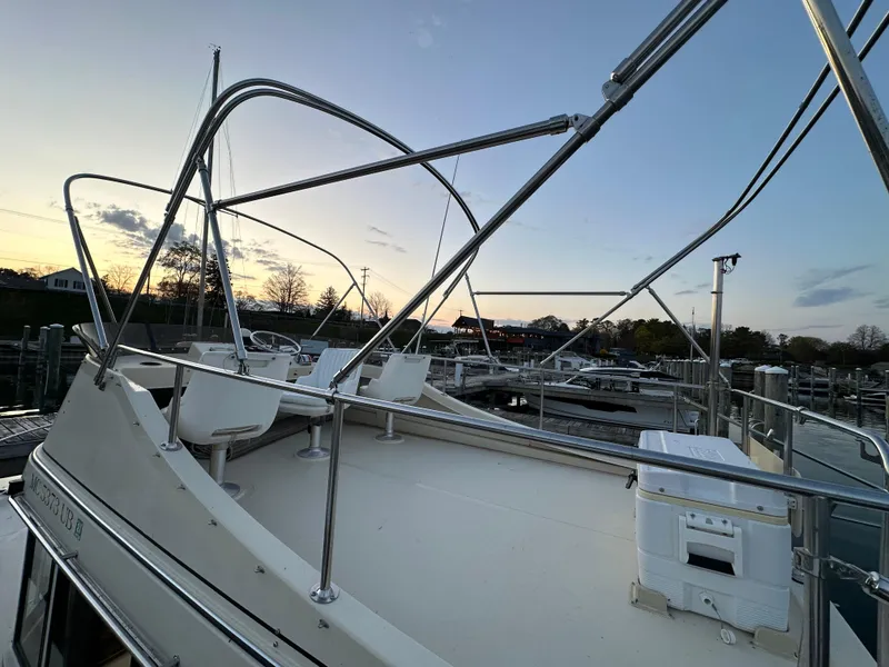 Slide: The Image of 2004 Camano Troll boat deck at sunset, featuring seating and railing. - 16