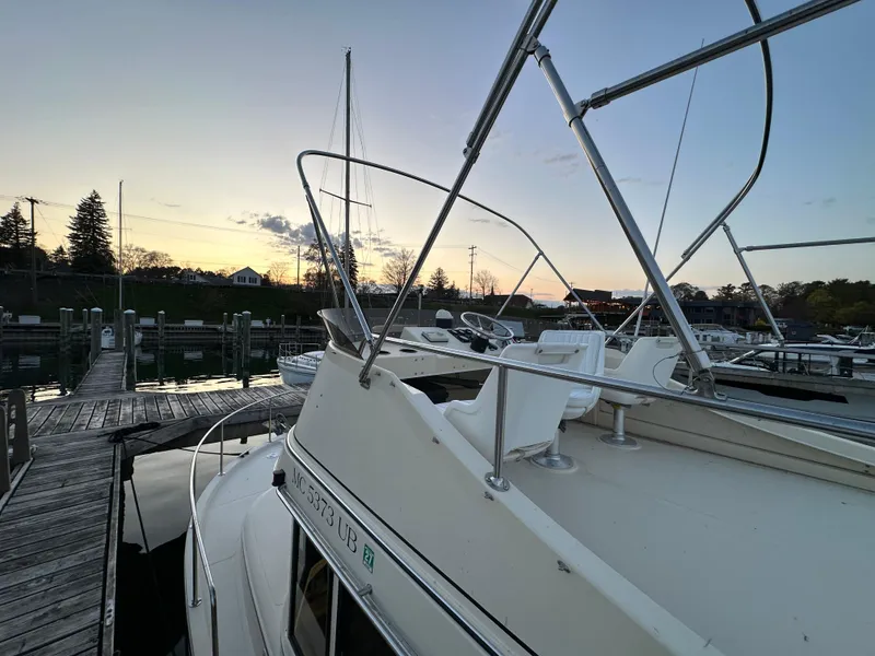 Slide: The Image of 2004 Camano Troll boat docked at sunset, showcasing sleek design and marina setting. - 17