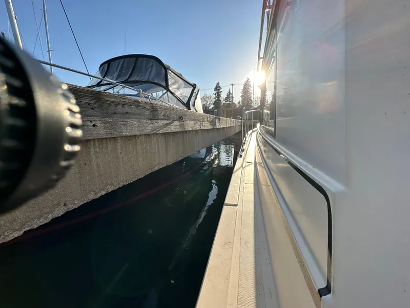 Slide: The Image of 2004 Camano Troll boat docked, sunlit marina view, calm water reflection. - 18