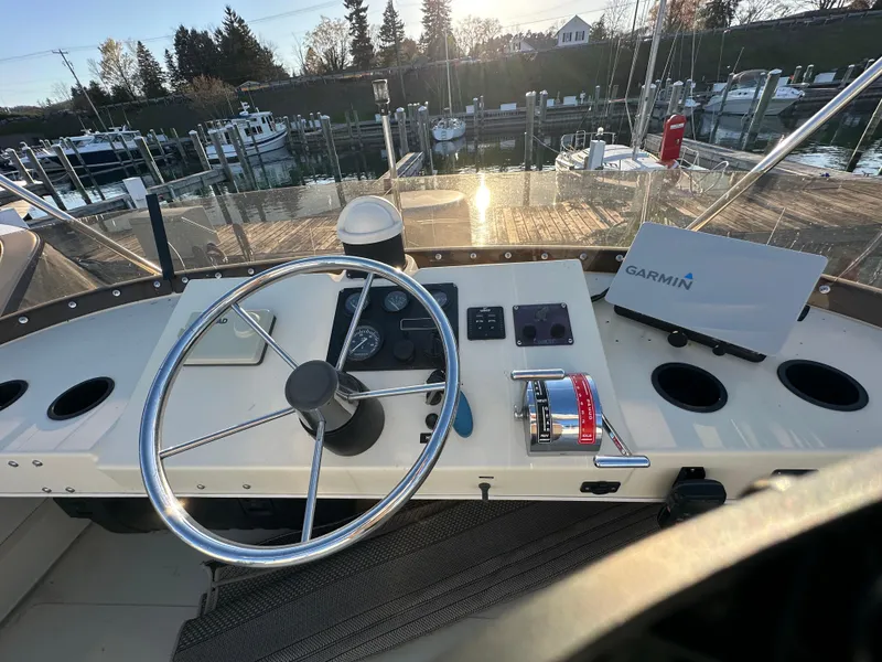 Slide: The Image of 2004 Camano Troll boat helm with steering wheel and Garmin navigation system. - 22