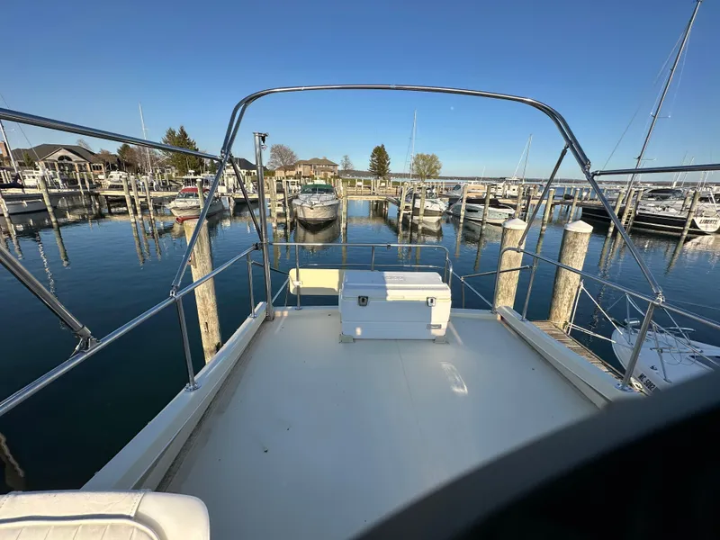 Slide: The Image of 2004 Camano Troll boat docked at a marina, clear sky, calm water. - 23