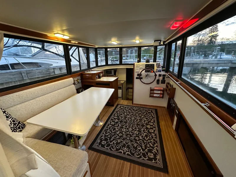Slide: The Image of Interior of a 2004 Camano Troll boat with seating, table, and helm station. - 24