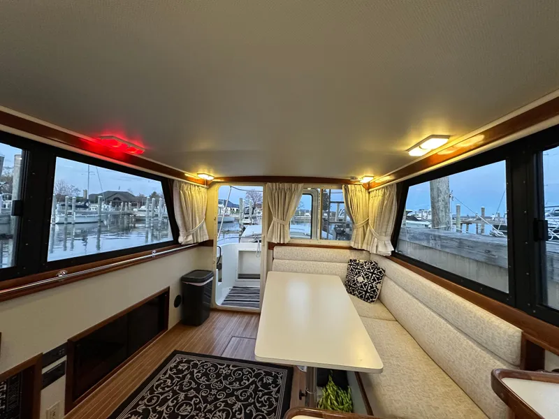 Slide: The Image of Interior of a 2004 Camano Troll boat with cozy seating and waterfront view. - 25