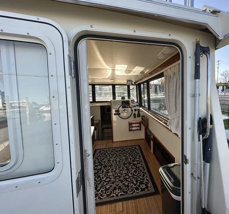 Slide: The Image of 2004 Camano Troll boat interior with helm, windows, and patterned rug. - 26