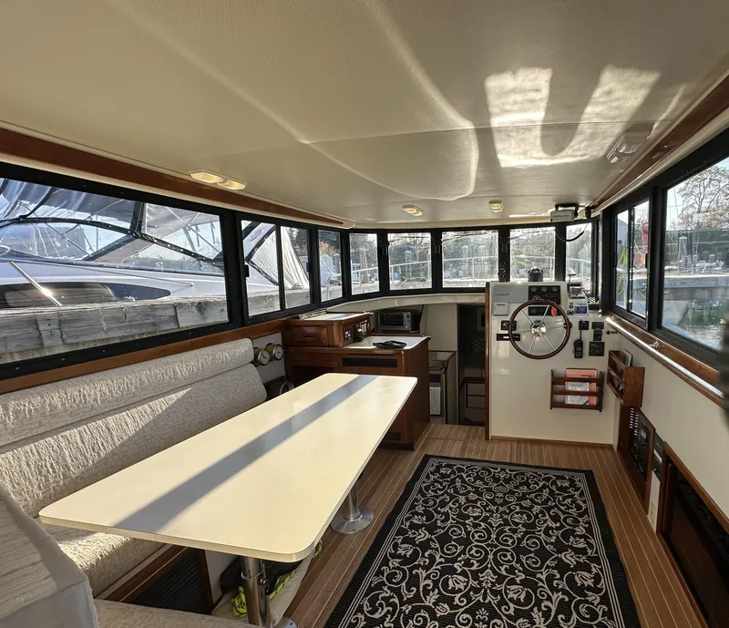 Slide: The Image of 2004 Camano Troll boat interior with dining area, helm, and panoramic windows. - 27