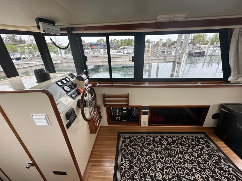 Slide: The Image of 2004 Camano Troll boat interior with helm, steering wheel, and marina view. - 30