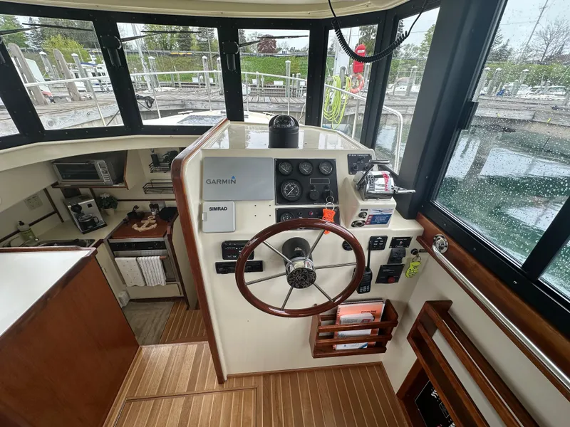 Slide: The Image of 2004 Camano Troll boat helm with wooden steering wheel and navigation equipment. - 32