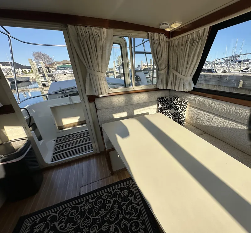 Slide: The Image of Interior of a 2004 Camano Troll boat with dining area and marina view. - 33