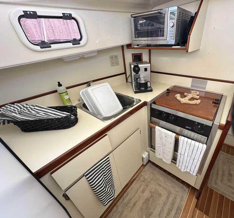 Slide: The Image of Compact 2004 Camano Troll boat kitchen with stove, sink, and appliances. - 37