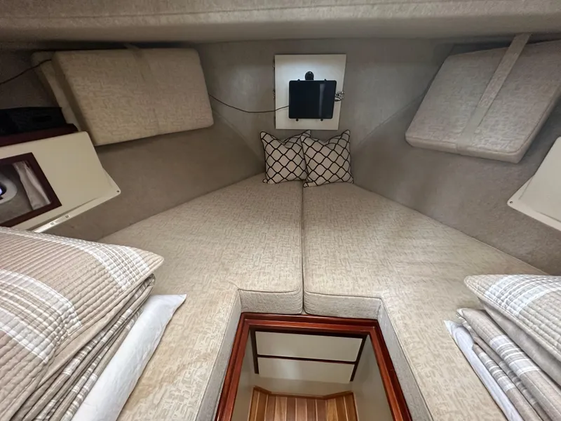 Slide: The Image of Interior cabin of a 2004 Camano Troll boat with cozy bedding and cushions. - 40