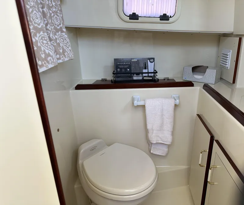 Slide: The Image of 2004 Camano Troll boat bathroom with toilet, towel, and storage cabinet. - 43