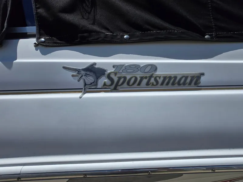 Slide: The Image of 2002 Wellcraft 180 Sportsman boat logo with marlin emblem on white hull. - 14