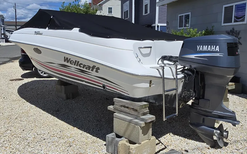 Slide: The Image of 2002 Wellcraft 180 Sportsman boat with Yamaha outboard motor, covered and elevated on blocks. - 4