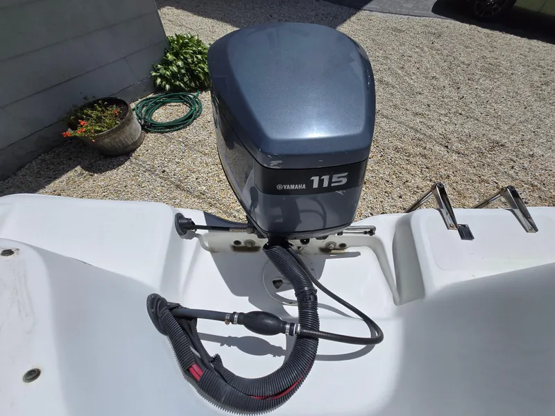 Slide: The Image of 2002 Wellcraft 180 Sportsman boat with Yamaha 115 outboard motor in a gravel driveway. - 6