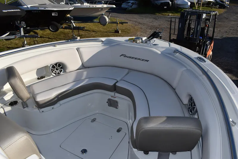 Slide: The Image of 2024 Finseeker 230 CC boat interior with cushioned seating and speakers. - 10