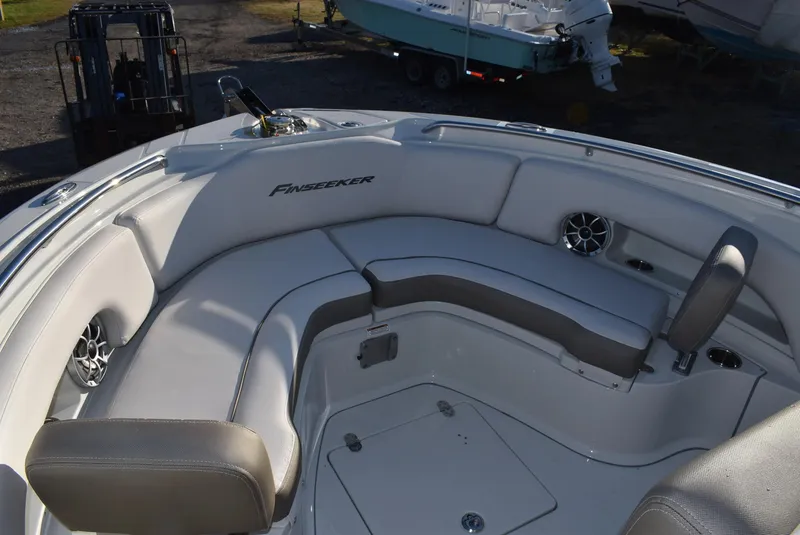 Slide: The Image of 2024 Finseeker 230 CC boat interior with cushioned seating and built-in speakers. - 11