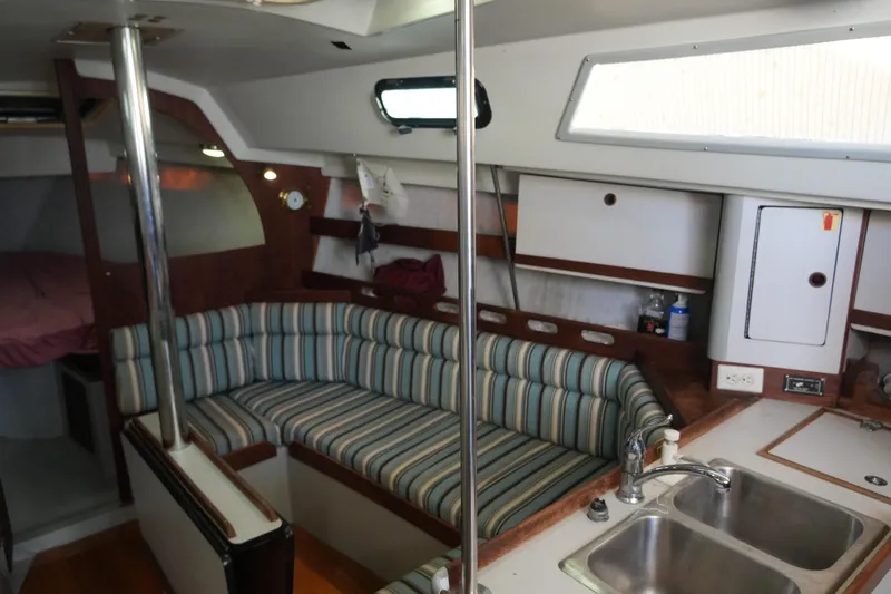 Slide: The Image of Interior of 1987 O'Day 322 sailboat with striped seating and kitchenette. - 13