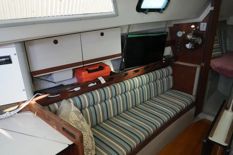Slide: The Image of 1987 O'Day 322 yacht interior with striped seating, storage, and navigation equipment. - 14