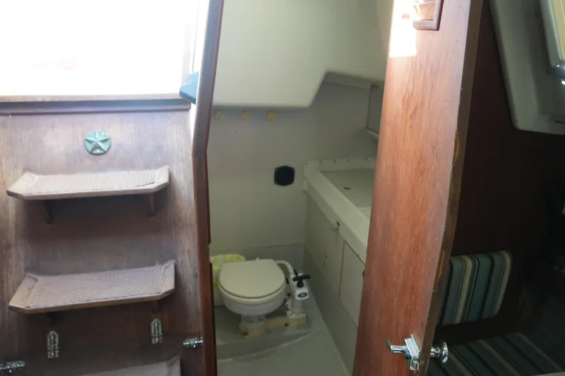 Slide: The Image of 1987 O'Day 322 yacht interior with wooden steps and compact bathroom. - 17