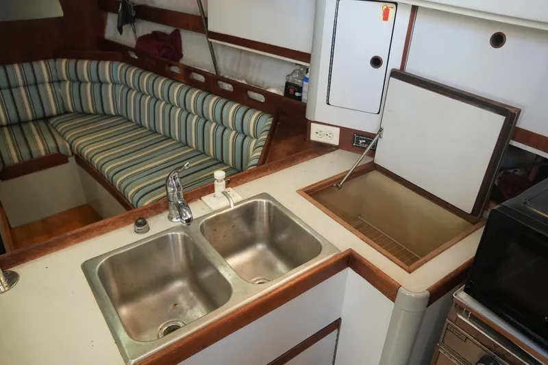 Slide: The Image of 1987 O'Day 322 yacht interior with kitchen sink and striped seating area. - 21