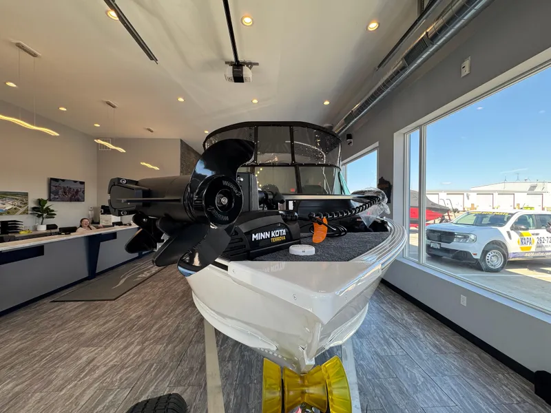 Slide: The Image of 2025 G3 AV17SF boat displayed indoors with Minn Kota motor, modern showroom setting. - 4