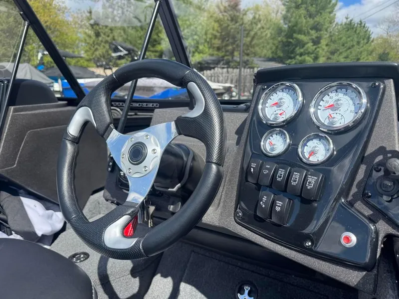 Slide: The Image of 2022 Tracker V-18 Targa dashboard with steering wheel and gauges in a boat cockpit. - 10