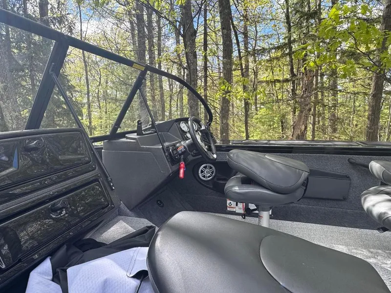 Slide: The Image of Interior of a 2022 Tracker V-18 Targa boat in a wooded area. - 9