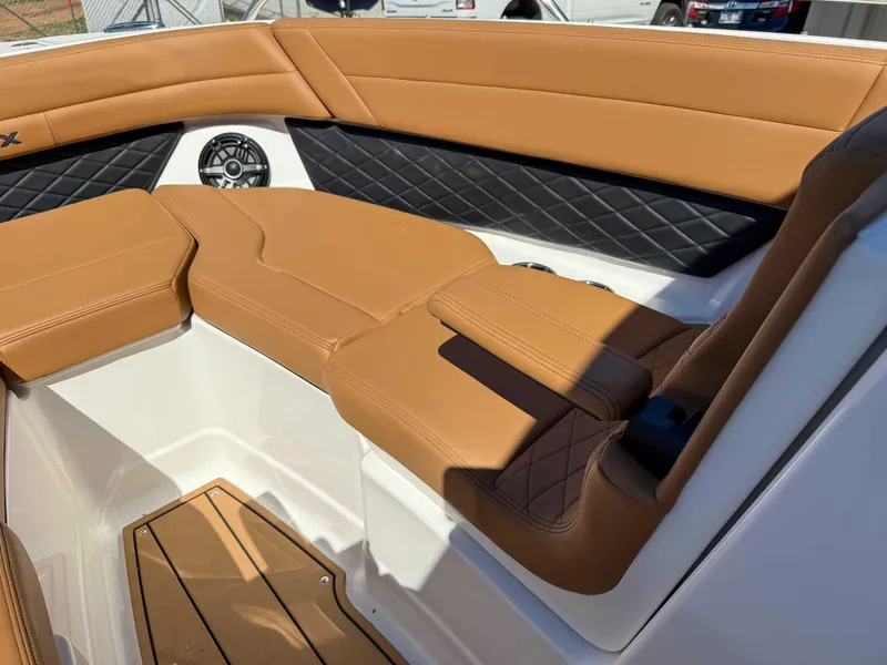Slide: The Image of 2025 Chaparral 267 SSX boat interior with tan and black seating, featuring diamond stitching. - 15