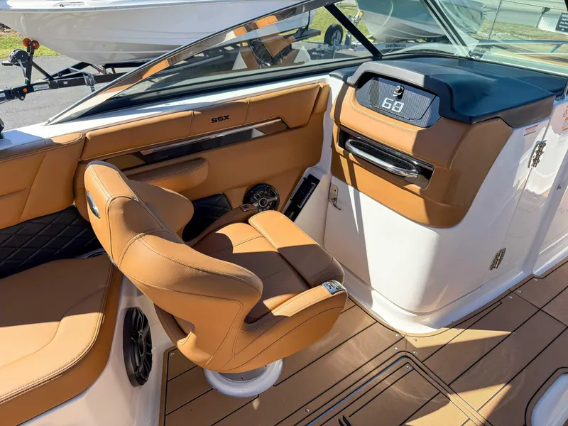 Slide: The Image of 2025 Chaparral 267 SSX boat interior with tan leather seating and modern dashboard. - 16